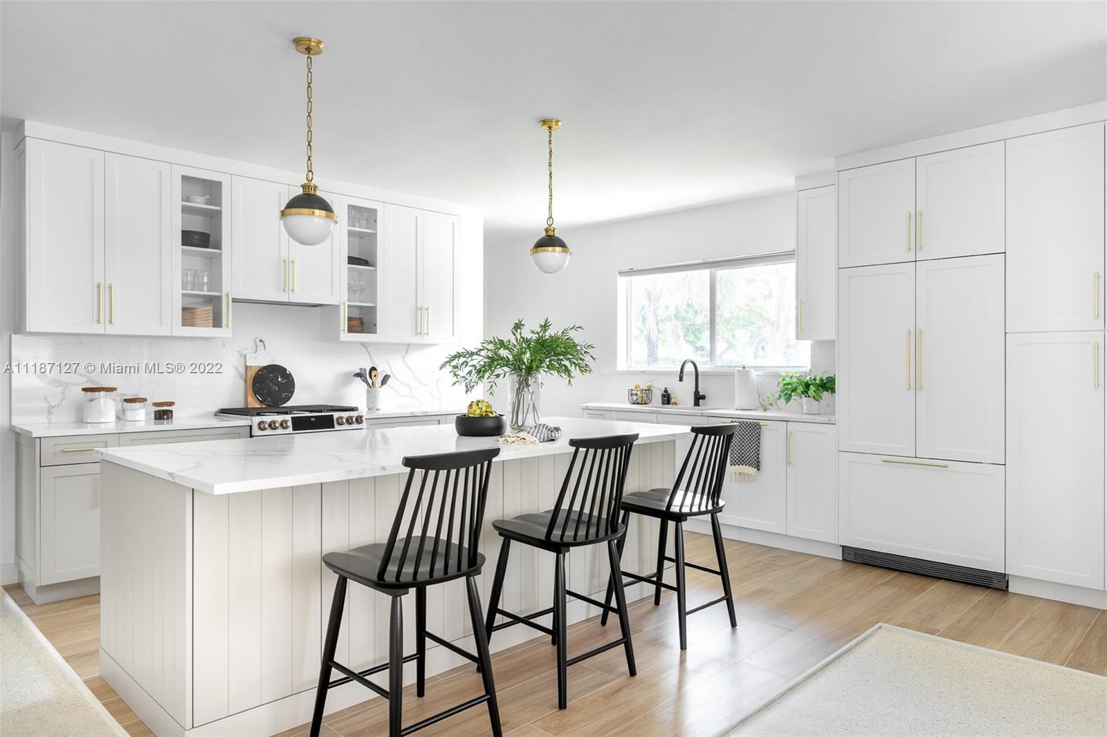a kitchen with stainless steel appliances white cabinets and a dining table
