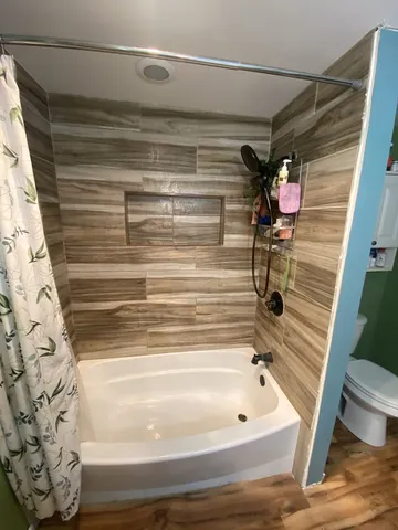 a bathroom with a bathtub and shower