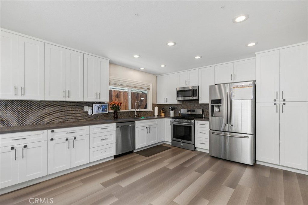 895 West Crestview Street Corona, CA 92882 - Photo 11 of 25 a kitchen with granite countertop white cabinets and stainless steel appliances