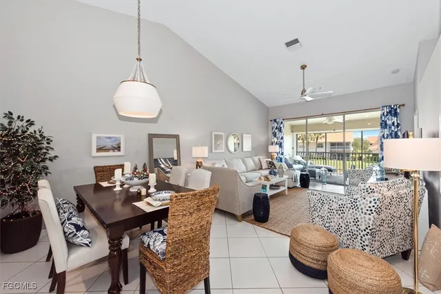 a living room with furniture kitchen view and a large window