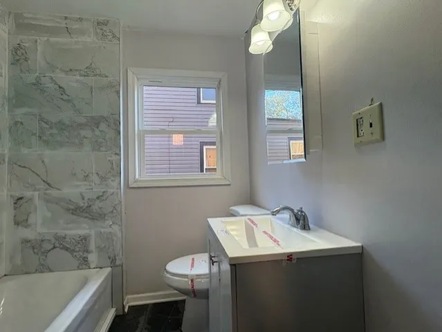 a bathroom with a sink a toilet and bathtub