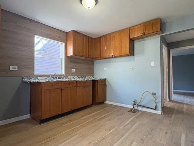 a kitchen with granite countertop wooden cabinets a sink and a stove