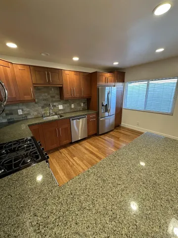a kitchen with stainless steel appliances granite countertop a sink stove and cabinets