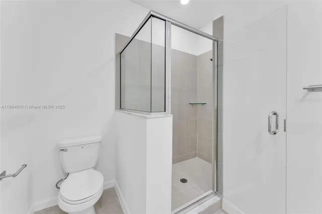 a bathroom with a toilet and a shower