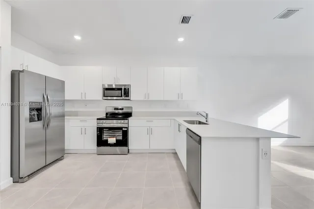 a kitchen with granite countertop a refrigerator stove and oven