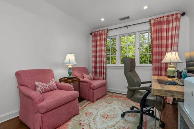 a bedroom with a bed and large windows