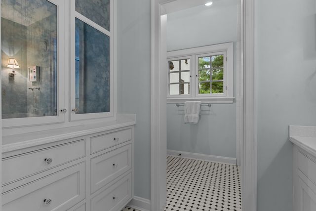 a bathroom with a sink a mirror and a window