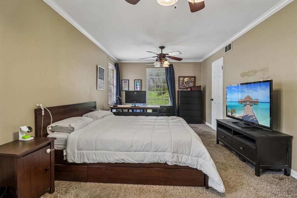820 North Bowen Road Arlington, TX 76012 - Photo 25 of 40 a bedroom with a bed and a flat screen tv