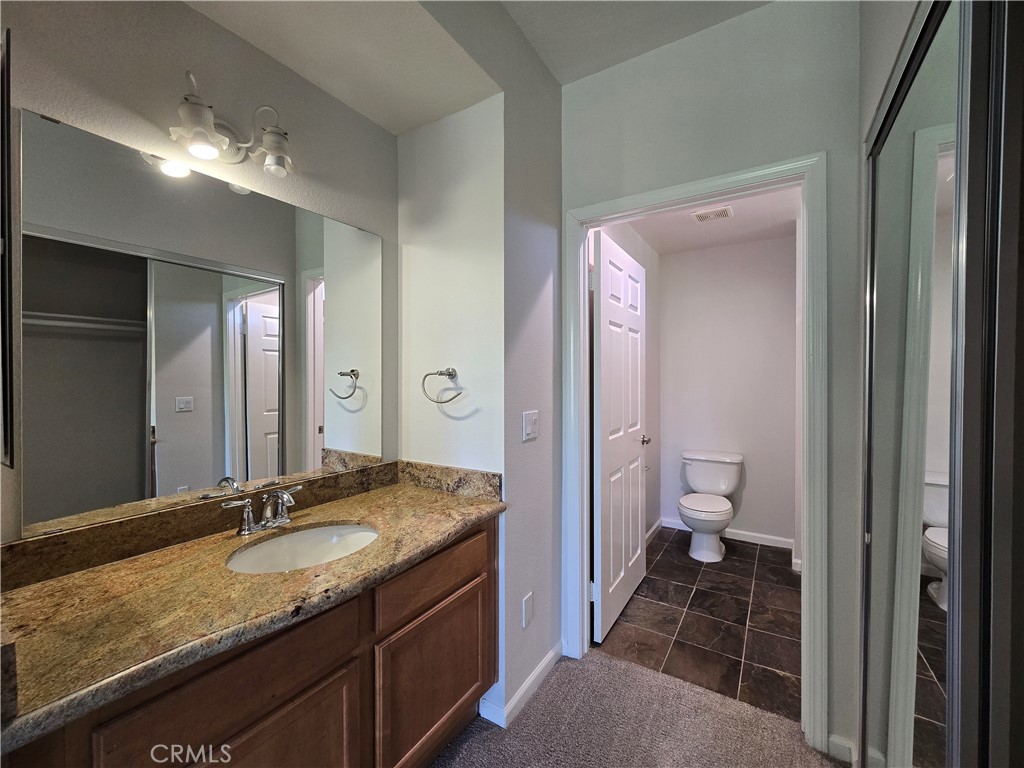 375 Central Avenue, Unit 14 Riverside, CA 92507 - Photo 15 of 22 a bathroom with a granite countertop sink a toilet and a large mirror