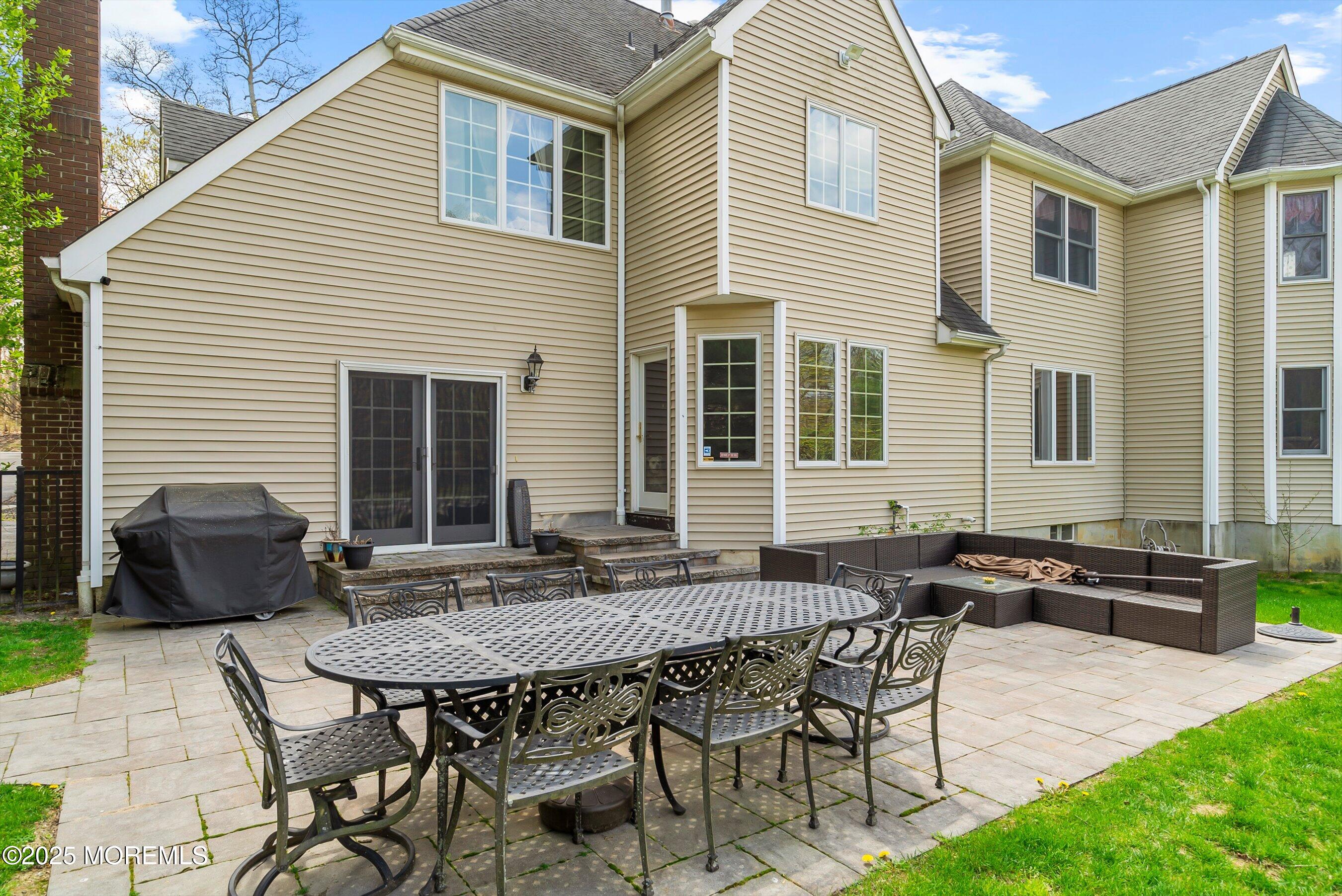 39 Primrose Lane Colts Neck, NJ 07722 - Photo 11 of 52 a backyard of a house with table and chairs