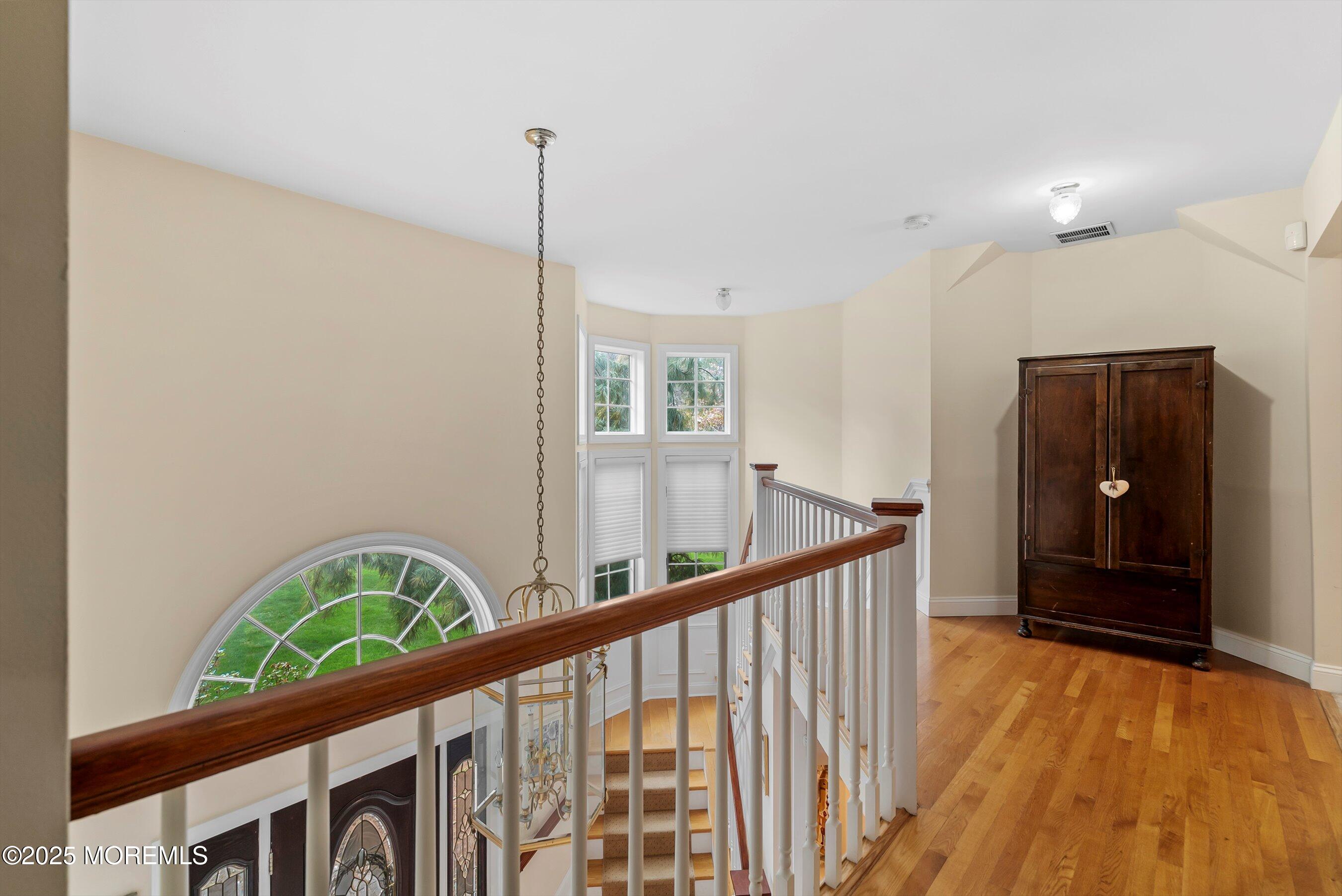 39 Primrose Lane Colts Neck, NJ 07722 - Photo 21 of 52 a view of a hallway with wooden floor and stairs
