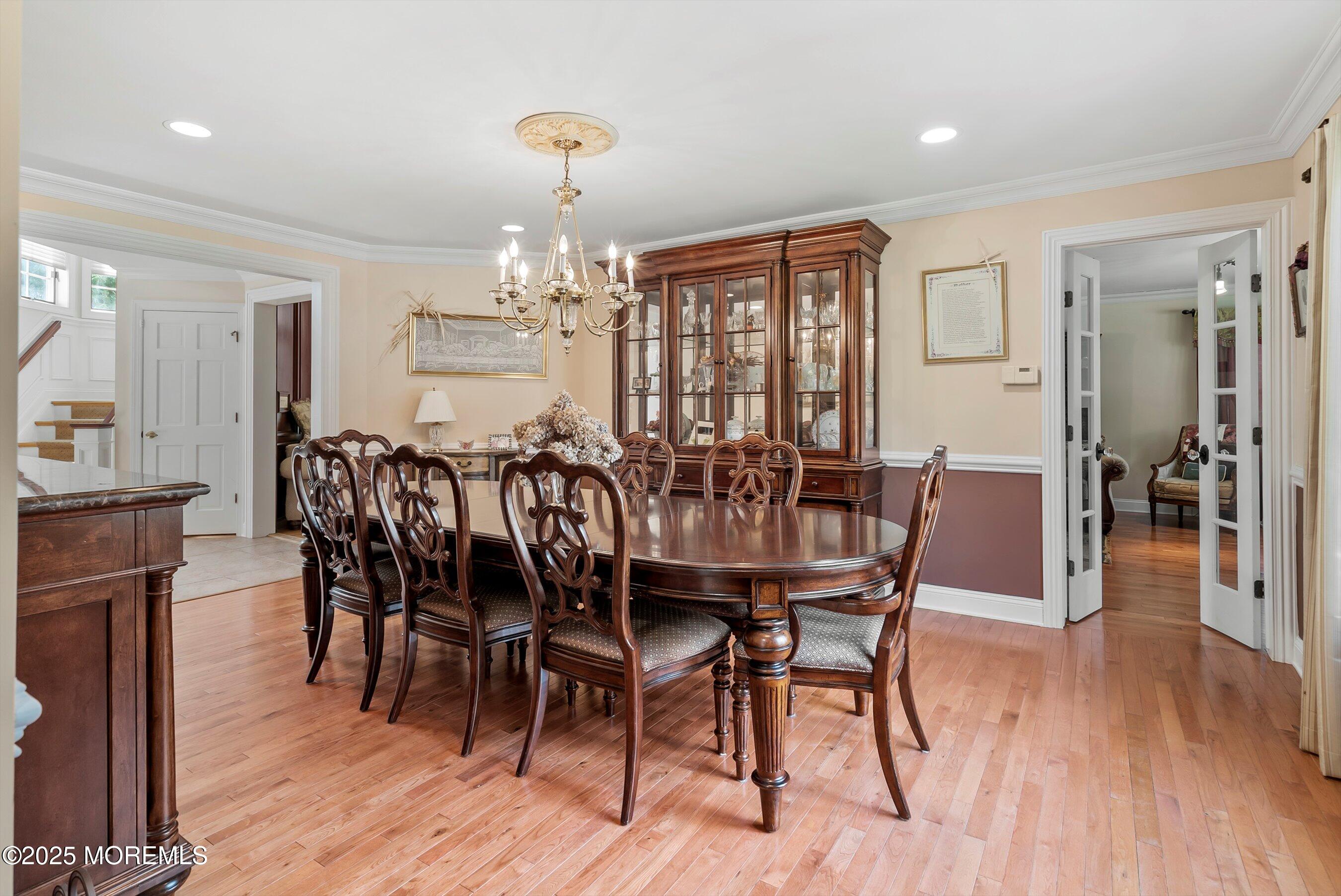 39 Primrose Lane Colts Neck, NJ 07722 - Photo 34 of 52 a dining room with furniture wooden floor a rug a potted plant and a chandelier