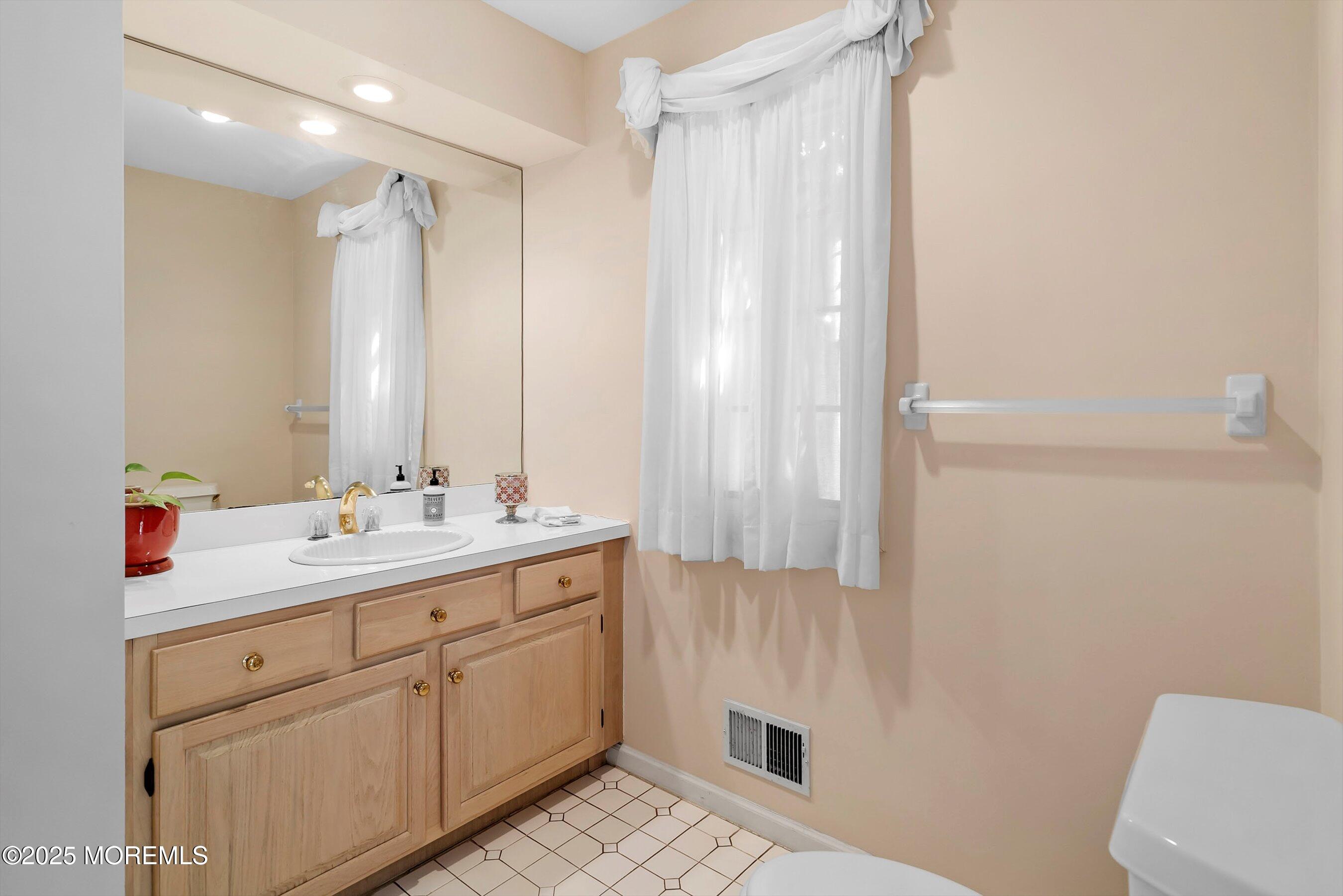 39 Primrose Lane Colts Neck, NJ 07722 - Photo 39 of 52 a bathroom with a sink a toilet and a mirror