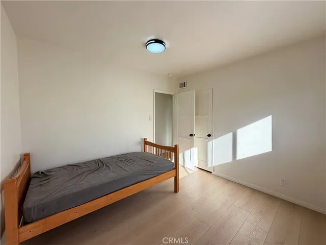 a view of a bedroom with wooden floor