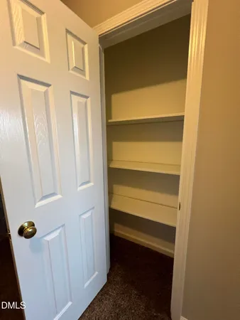 an empty room with windows and chandelier fan