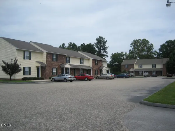 a front view of a house with a garden and parking