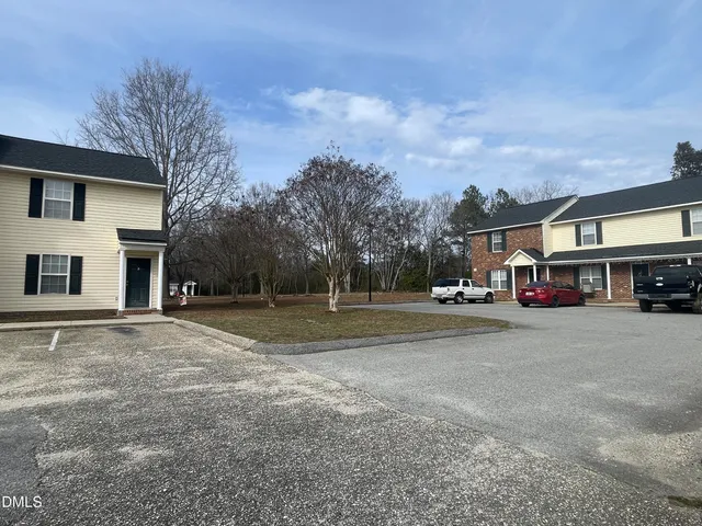 a building view with couple of cars parked in front of it