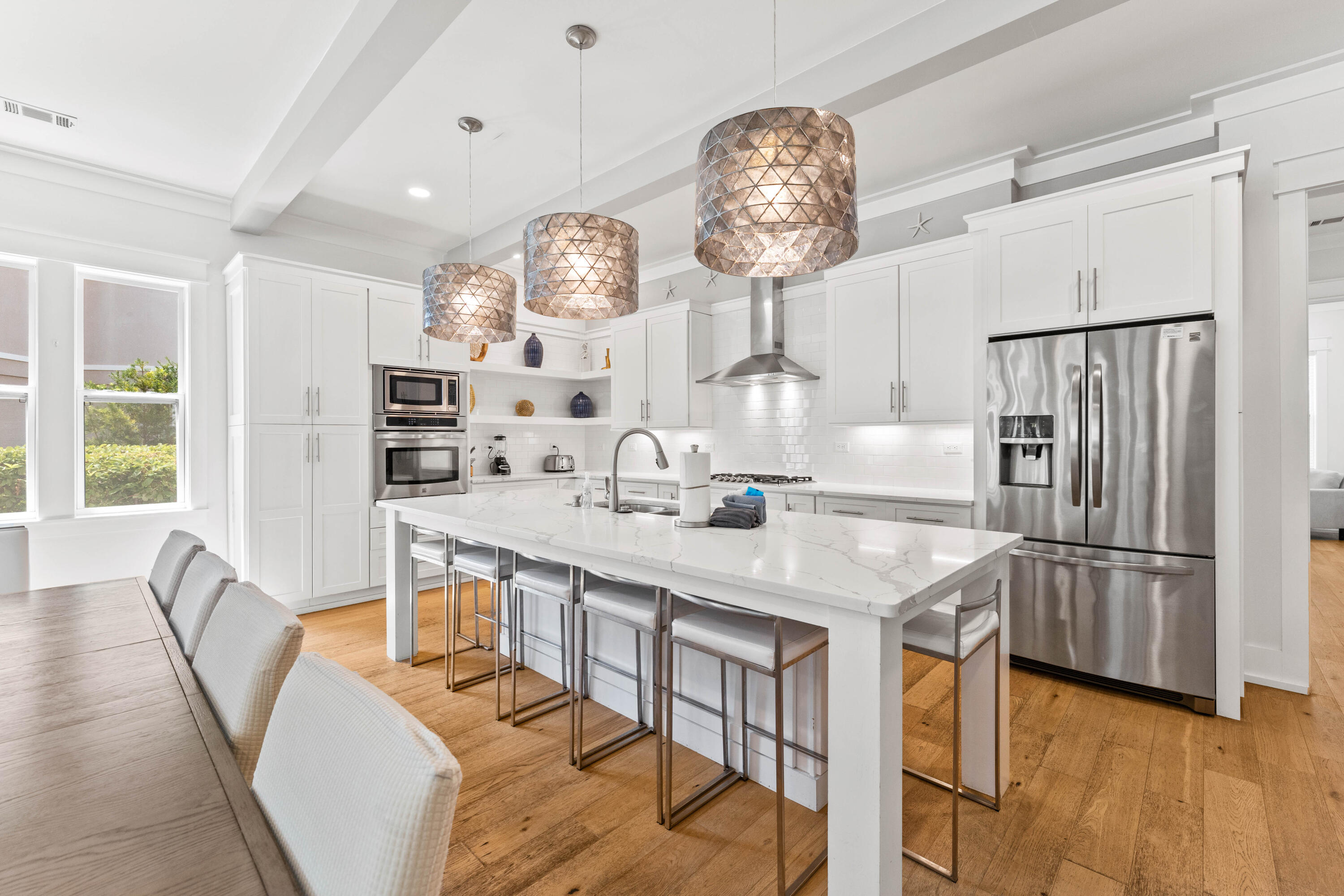 4635 Sunset Pointe Destin, FL 32541 - Photo 5 of 48 a kitchen with stainless steel appliances a table chairs and chandelier