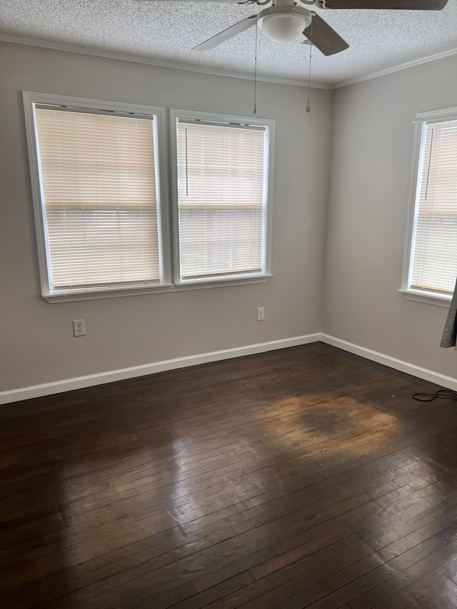 2361 Susan Drive Crestview, FL 32536 - Photo 9 of 12 an empty room with wooden floor and windows