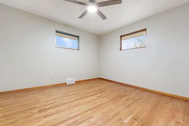 a view of an empty room with wooden floor