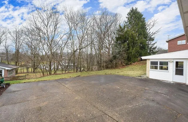 a view of a house with backyard and trees