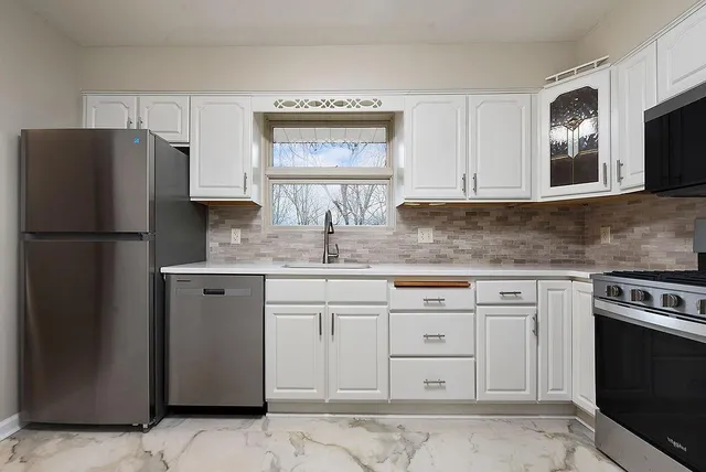 a kitchen with cabinets stainless steel appliances and a counter space