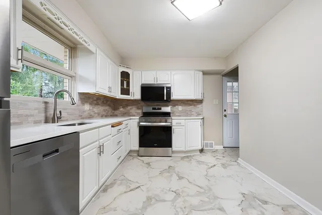 a kitchen with a sink stove and microwave