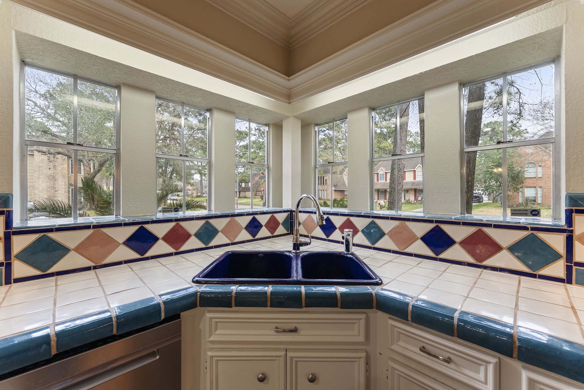 5718 Glenmere Lane Spring, TX 77379 - Photo 13 of 40 The kitchen sink is perfectly positioned beneath a beautiful corner of windows, filling the space with natural light.