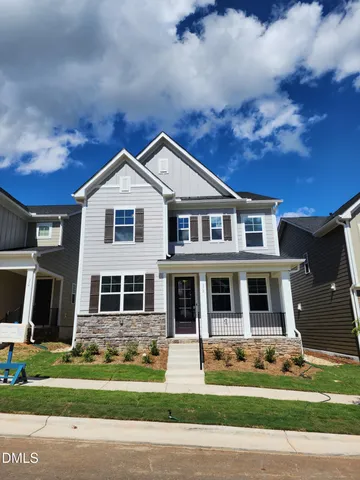 a view of a brick house with a yard in front of it