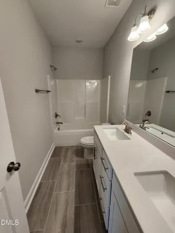 a room with gym equipment and wooden floor