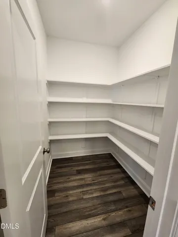 a kitchen with stainless steel appliances white cabinets and a wooden floor