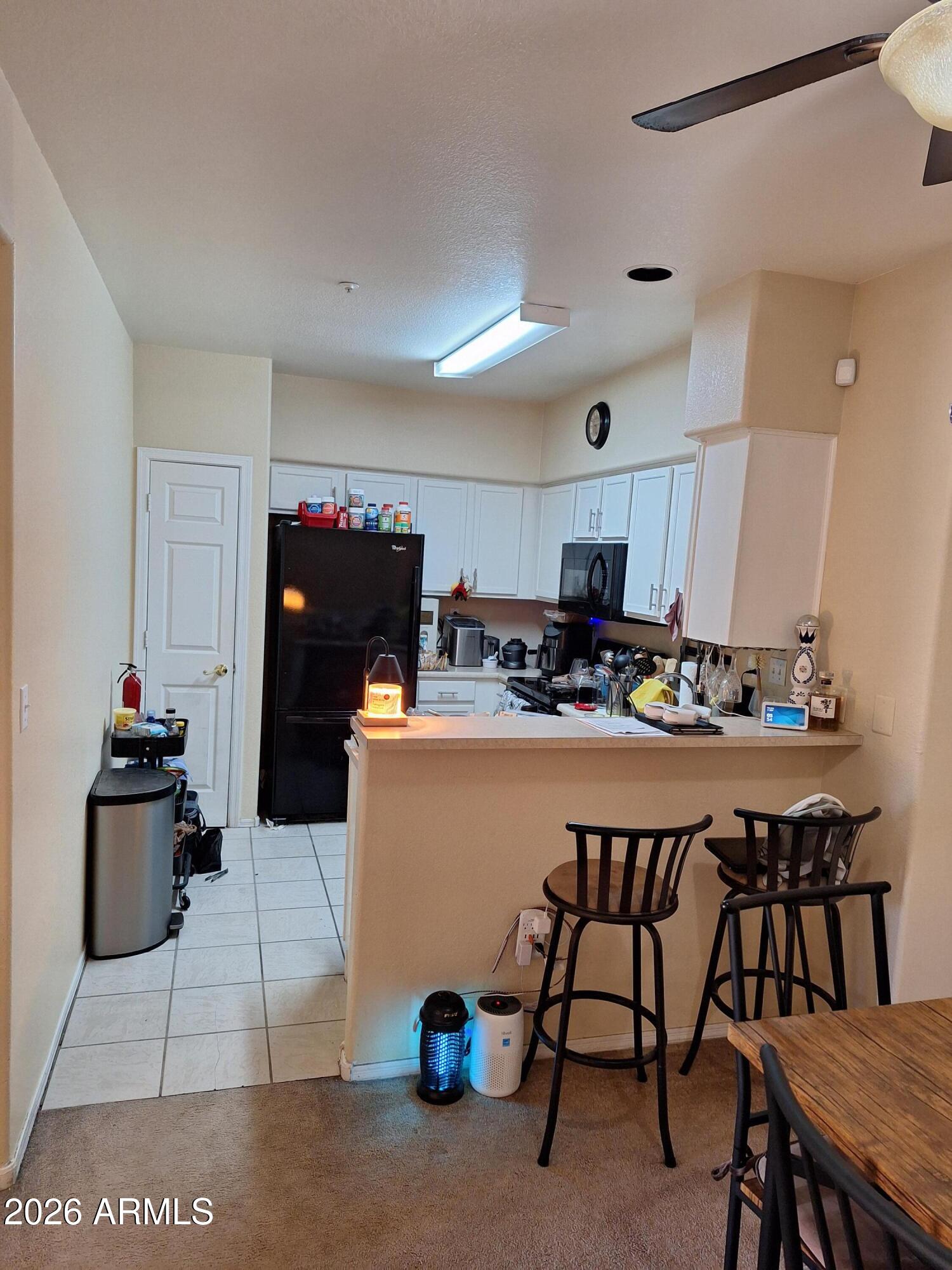 10410 North Cave Creek Road, Unit 2063 Phoenix, AZ 85020 - Photo 28 of 49 a kitchen with a table chairs and a refrigerator