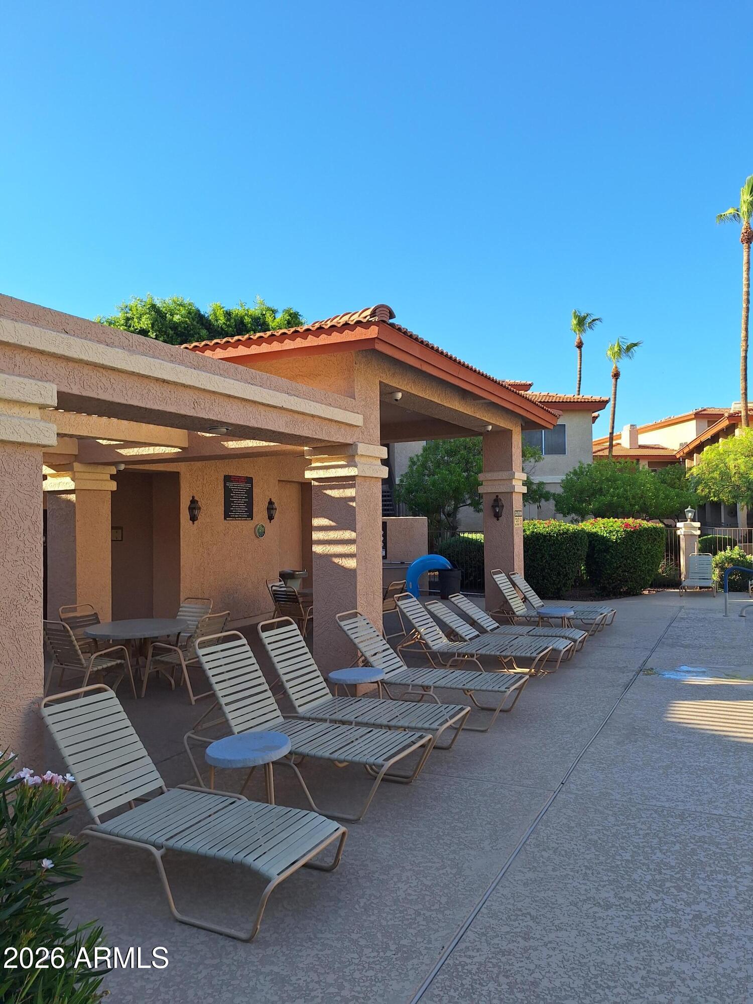 10410 North Cave Creek Road, Unit 2063 Phoenix, AZ 85020 - Photo 3 of 49 a view of a patio with table and chairs with wooden floor and fence