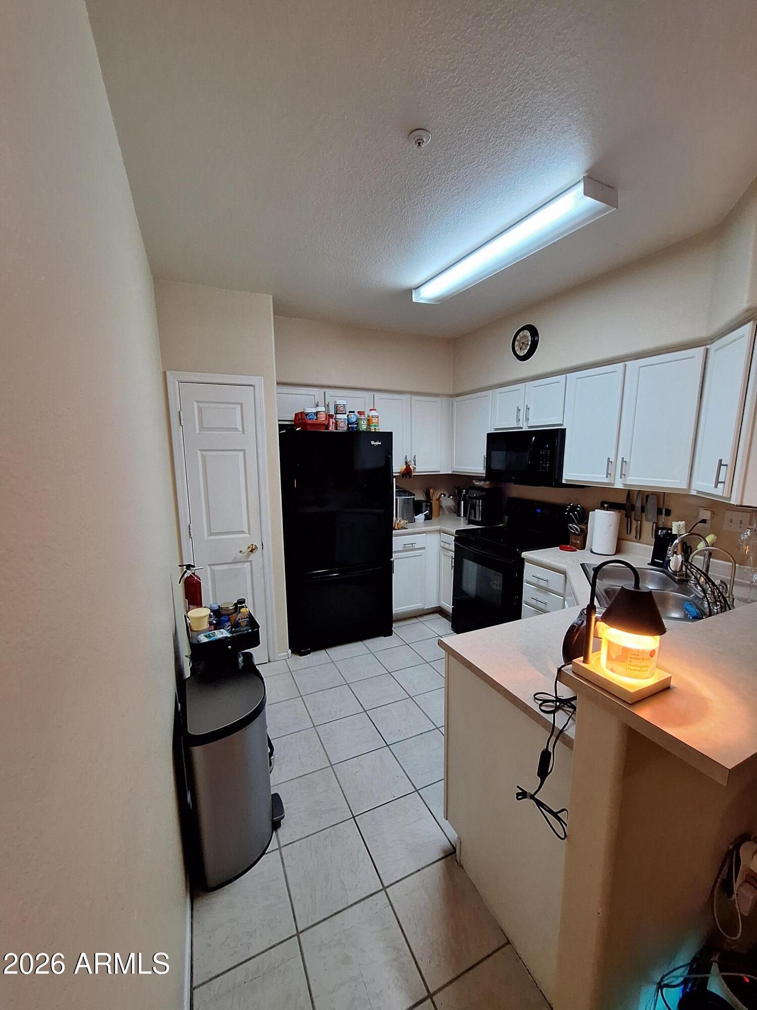 10410 North Cave Creek Road, Unit 2063 Phoenix, AZ 85020 - Photo 31 of 49 a kitchen with cabinets and black appliances