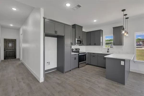 a kitchen with a sink refrigerator and cabinets