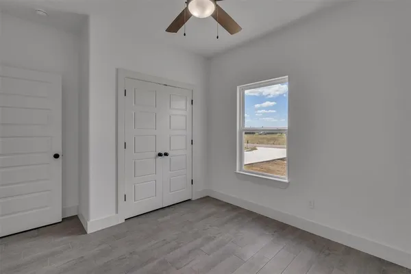 an empty room with a window and a ceiling fan