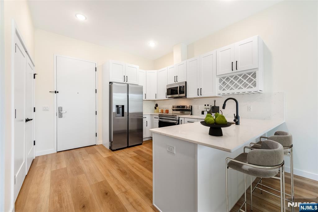51 Queen Anne Road, Unit 405 Bogota, NJ 07603 - Photo 3 of 17 a kitchen with stainless steel appliances a sink stove and refrigerator