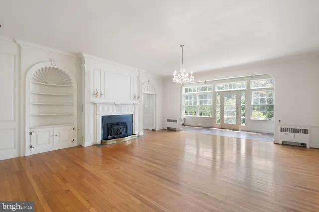 a view of empty room with wooden floor and fireplace