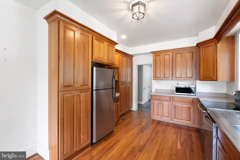 a kitchen with a refrigerator a sink dishwasher and a stove with wooden floor