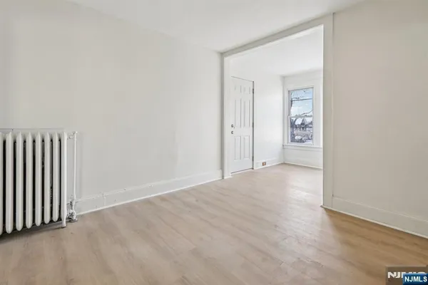 a view of a hallway with wooden floor and closet