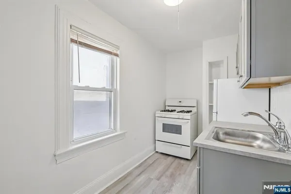a kitchen with a stove a sink and a window