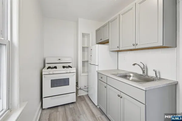 a kitchen with white cabinets sink and white appliances