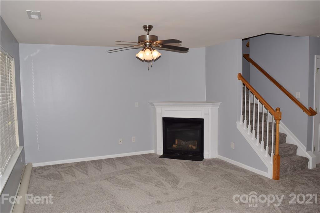 138 Limerick Road Mooresville, NC 28115 - Photo 5 of 33 an empty room with a fireplace and fan