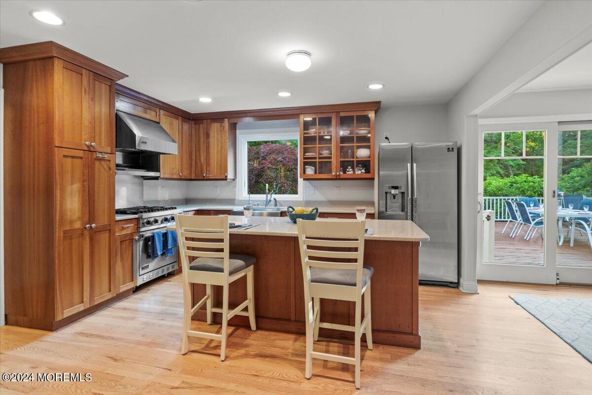 676 Locust Point Road Atlantic Highlands, NJ 07716 - Photo 16 of 56 a kitchen with stainless steel appliances kitchen island granite countertop a refrigerator a stove a microwave oven a sink with island and chairs