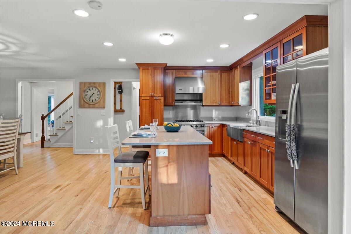 676 Locust Point Road Atlantic Highlands, NJ 07716 - Photo 17 of 56 a kitchen with stainless steel appliances granite countertop a refrigerator a stove top oven a sink dishwasher and wooden cabinets with wooden floor