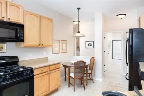 a kitchen with stainless steel appliances granite countertop a stove a refrigerator a kitchen island a sink a stove and white cabinets