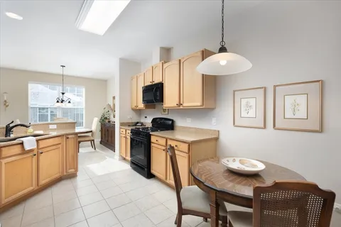 a kitchen with stainless steel appliances kitchen island granite countertop a sink a stove a microwave a dining table and chairs