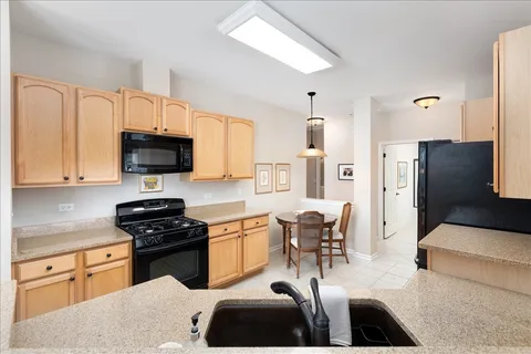 a kitchen with stainless steel appliances a stove a sink a microwave a refrigerator cabinets and furniture