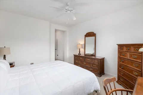 a bedroom with a bed and dresser with mirror