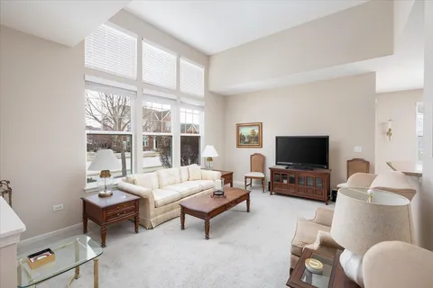 a living room with furniture a flat screen tv and a large window